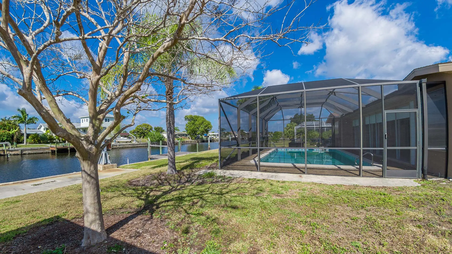 Aluminum pool cage next to a large tree